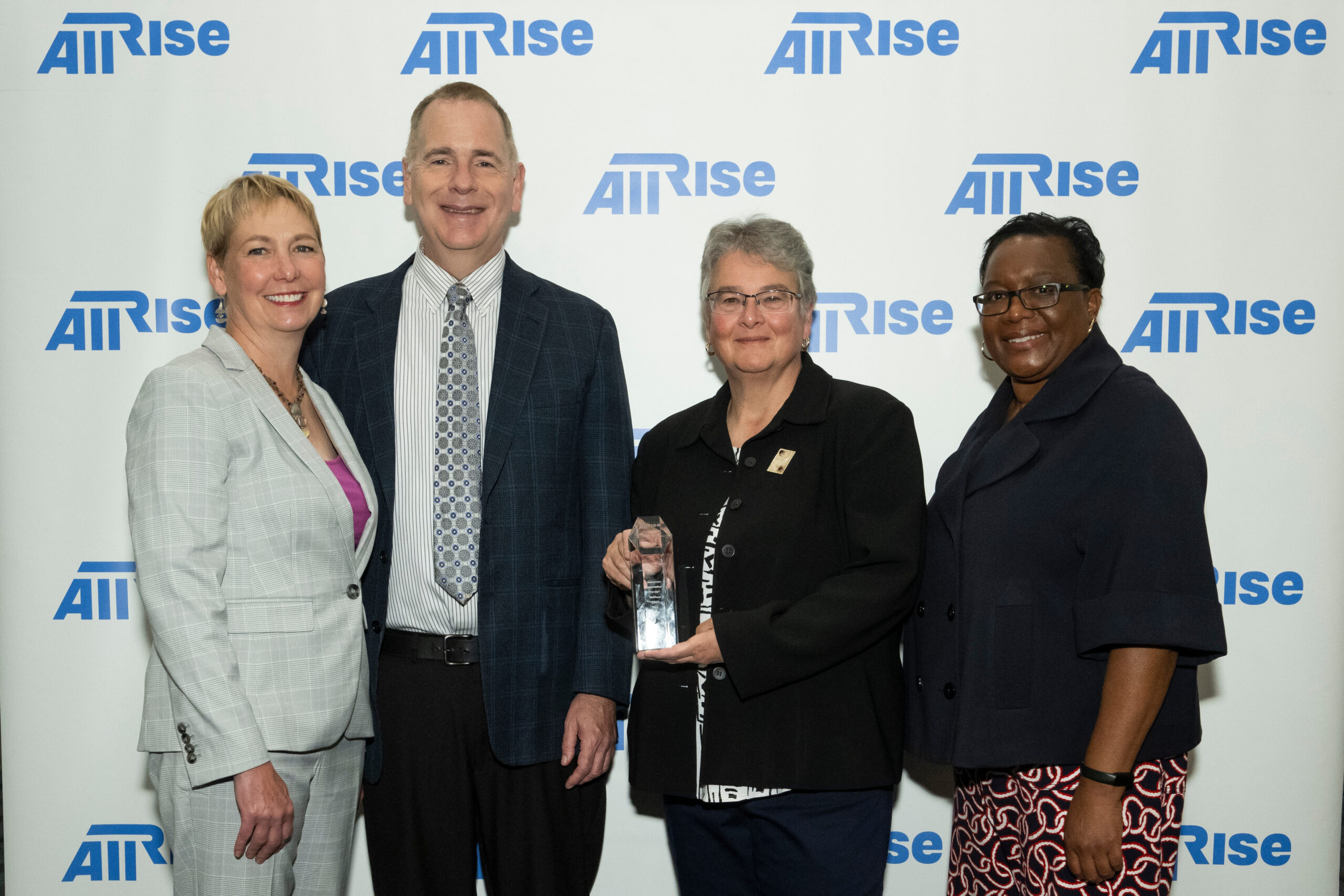 All Rise CEO Carson Fox, second from left, and chief of training and research Carolyn Hardin, right, present the Stanley Goldstein Treatment Court Hall of Fame Award to loved ones of the late Carol Venditto.