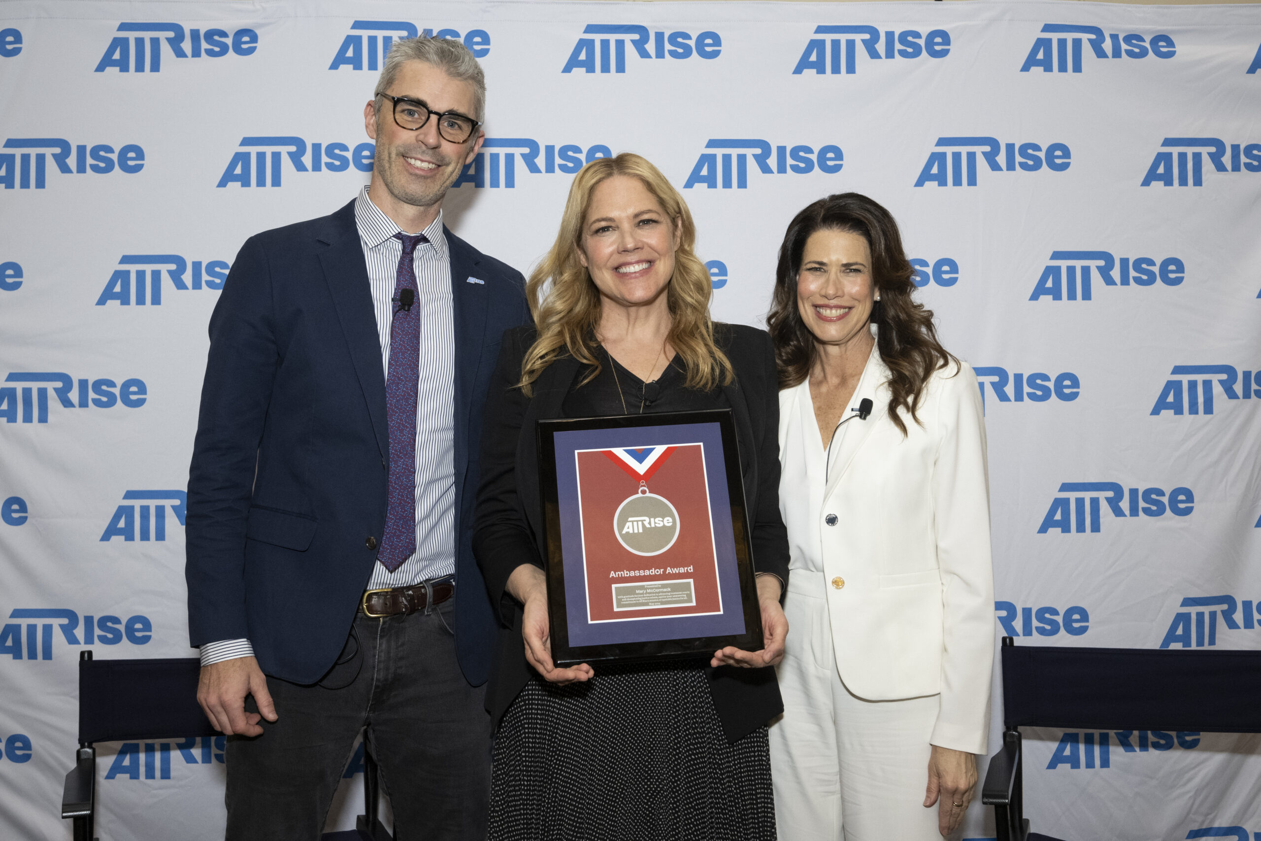 All Rise director of communications Chris Deutsch, left, and All Rise director of strategic engagement Melissa Fitzgerald, right, present the All Rise Ambassador Award to actor and author Mary McCormack, center.